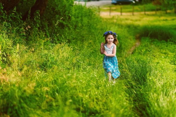 Schöne 5-jährige Mädchen im Kranz aus Kornblumen Tornister im Sommer läuft über die Wiese in blauem Kleid. Naturverbundener Lebensstil in der Kindheit. Sommer gefährliche Zeit für Allergiker. — Stockfoto