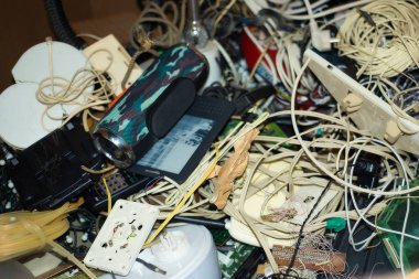 Çöpe atılan aletlerin e-atık yığınları. Bağlayıcılar, kablolar, e-kitaplar, kartlar. Renkli bulanık arkaplan bileşenleri. Elektronik sanayi, eko, elektronik atık tasnif ve imhası