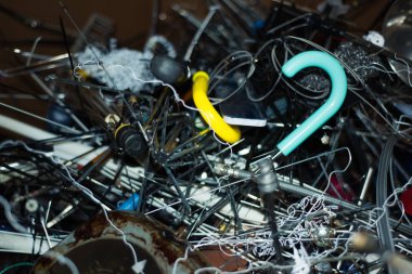 Kırık şemsiyelerin metal parçalarından ve atık tasnif istasyonundaki diğer metallerden atık yığınları. Renkli bulanık arkaplan bileşenleri. Çevre, tasnif, geri dönüşüm ve çöp öğütme kavramı