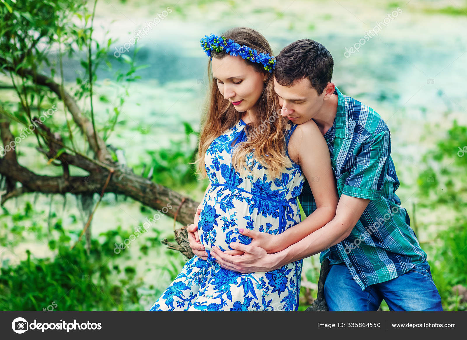 Happy and young pregnant couple hugging in nature on sunset. New family Happy and young pregnant couple hugging in nature on sunset. New family