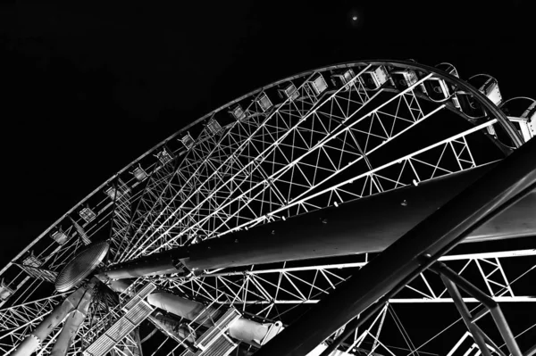 Black and white picture of ferris wheel in nighttime with beautiful backlight. Bottom view on famous Budapest, Hungary, attraction ferris wheel in night. Design pattern. Abstraction. — Stock Photo, Image