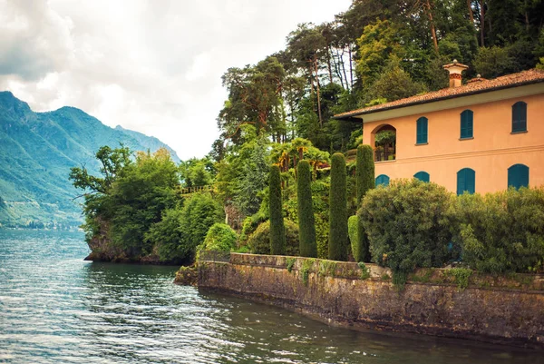 Вилла с садом в Белладжо на берегу озера Комо, Ломбардия, Италия. Удивительный вид на голубое озеро и Альпы на заднем плане. Комо известный популярный туристический курорт — стоковое фото