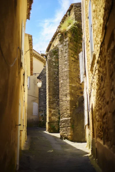 Vertical picture of scenic stone medieval narrow street in Lourmarin, one of the most beautiful villages of France located in Luberon, heart of Provence. Famous popular tourist destination. — Stock Photo, Image