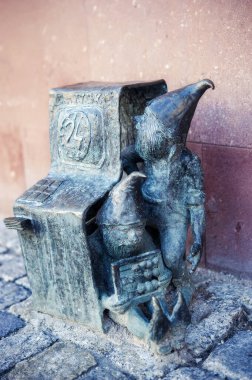 Wroclaw, Polonya 'da ATM tamir eden iki cüce. Wroclaw 'daki ünlü cüce heykellerinden biri, geçmişte Breslau, Polonya şehrinin sembolleri. Seyahat güzergahı. Turizm cazibesi.