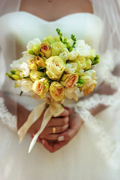 Beau bouquet de mariage avec des roses crémeuses et jaunes dans les mains de la mariée le jour du mariage. Décor de mariage. Idée pour le bouquet de mariée. Fleurs dans les mains des femmes — Photo