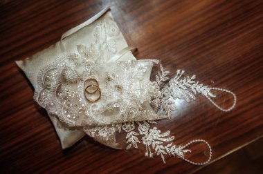 Evlilik yüzükleri kavramsal koyu arkaplanda, dantel eldivenli. Düğün günü gelin ve damat yüzüğü. Evlilik için dekorasyon. Düğün dekoru