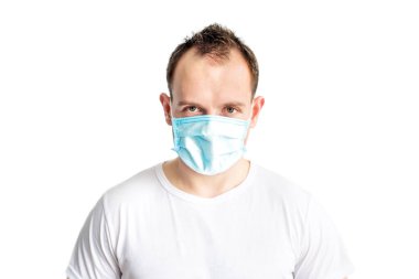 Yüzünde mavi tıbbi maske takan ciddi ve kendine güvenen beyaz bir adamın portresi. Soğuk mevsimde sağlık hizmeti. Coronavirus covid-2019 'un önlenmesi. Koronavirüsü durdurun. Sağlık ve Sağlık Hizmetleri.