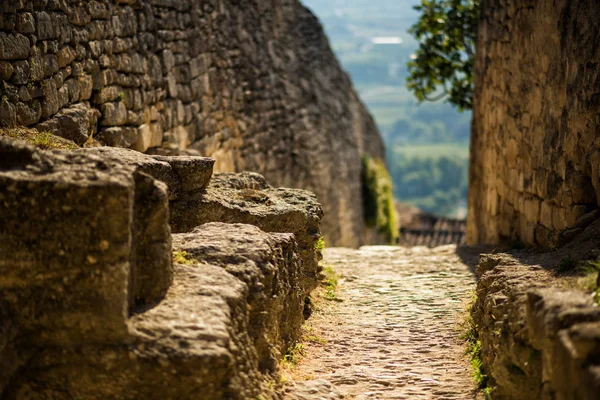 Medieval stone wall of castle of notorious Marquise de Sade in Lacoste, Provence, France. Ruins of old castle in Europe in hot summer day. Travel tourism destination Provence-Alpes-Cote-d\'Azur.