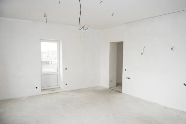 Alçıpan döşenmiş ve boyanmamış, duvarlar sıvanmış ve elektrik kabloları döşenmiş konut projesinin iç inşaatı
