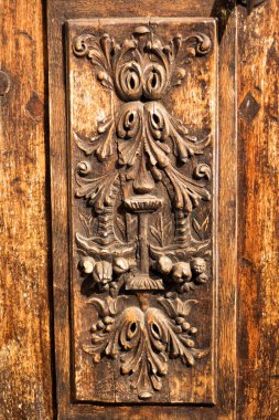 Ahşap giriş kapısına geleneksel oyma dekorasyonun dikey resmi. Provence, Fransa 'da oyulmuş ahşap elementler. Otantik yerel provenkal bina dekoru. Ahşap oyma sanatının ayrıntıları.