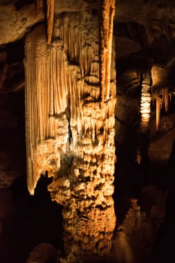 Fransa 'nın Ardeche bölgesindeki Aven dOrgnac mağarasındaki dikey dikey dikitler ve sarkıtlar. Ünlü speleoloji turizm merkezi..