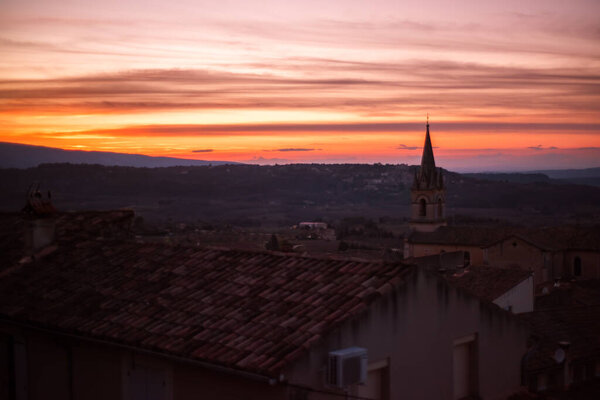 Famous traditional historic provencal village Bonnieux, France, Provence, Luberon, Vaucluse in sunset time with dusk and bright colorful sky. View from the top of village. Travel tourism destination.