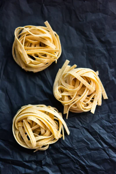 Vertical Picture Three Pieces Traditional Italian Raw Uncooked Pasta Tagliatelle — Stock Photo, Image