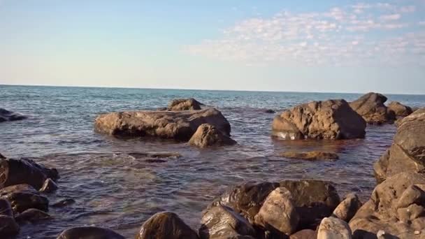 在大海的岩石海岸上 海浪带着噪音滚到岩石海岸上 日出在海边 美丽的海景 汹涌大海中的岩石海岸 海浪拍打着海岸 — 图库视频影像