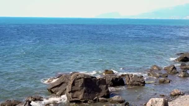 在大海的岩石海岸上 海浪带着噪音滚到岩石海岸上 日出在海边 美丽的海景 汹涌大海中的岩石海岸 海浪拍打着海岸 — 图库视频影像