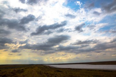 Dönen bir nehrin arkaplanındaki bulutlardaki güneş.