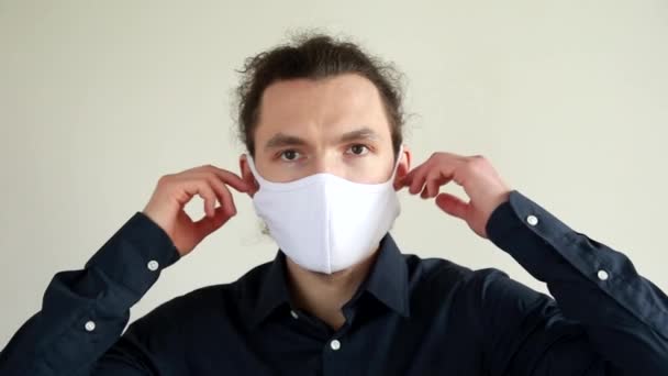 Een jonge blanke man doet zijn beschermend masker af. Het concept van het beëindigen van de pandemie en een uitweg uit quarantaine. — Stockvideo