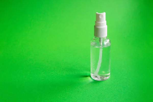 Hand picked alcohol antiseptic on green background. Hygiene and coronavirus prevention concept. — Stock Photo, Image