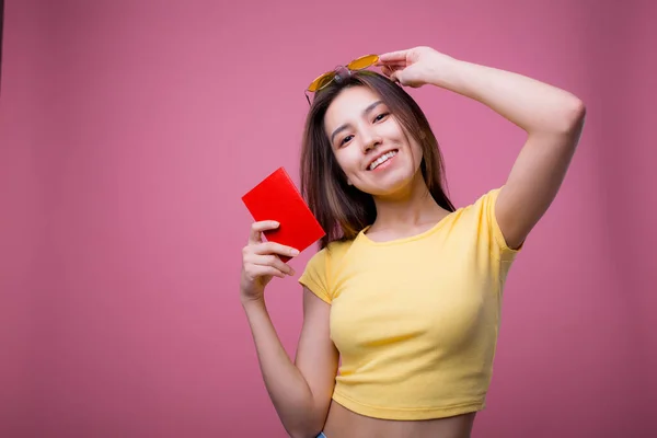 Beau portrait jeune femme asiatique porter des lunettes de soleil sur la tête sourire confiant profiter des vacances d'été isolé fond bleu, modèle fille mode hipster tenant passeport, concept de voyage . — Photo