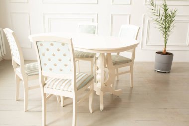 White tables and chairs for dinner in a classic interior.