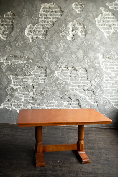 Einzelner brauner Tisch mit leerer Oberfläche und geschnitzten Beinen im Loft-Innenraum — Stockfoto