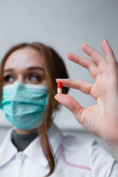 Concetto di medicina - bella ragazza medico tiene pillola per la malattia — Foto Stock