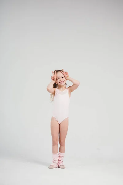 Gymnaste fille souriante posant en vêtements de sport. Enfant isolé avec fond blanc . — Photo
