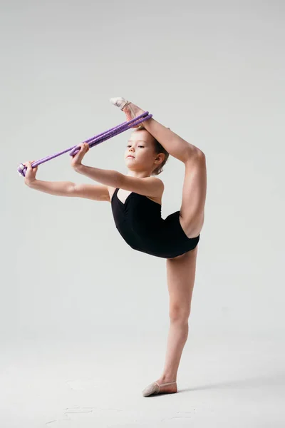 Gymnaste effectue l'exercice debout sur une jambe et en utilisant de l'équipement . — Photo