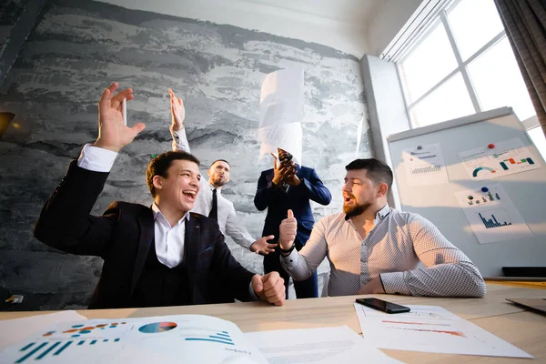 Joyful businessmen rejoicing at the conclusion of a contract for the supply of new goods