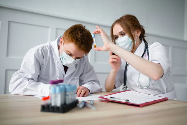 Dois médicos e assistentes de laboratório italianos examinam testes de pacientes para novas infecções por vírus — Fotografia de Stock