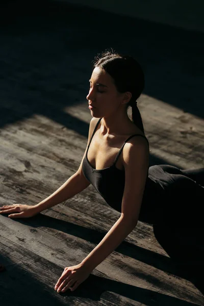 Fata în negru sport face yoga pe podea în sala de gimnastică . — Fotografie, imagine de stoc