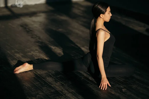 Fata în negru sport face yoga pe podea în sala de gimnastică . — Fotografie, imagine de stoc