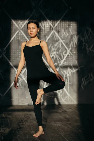 O tânără stă pe un picior. Clasa de yoga în sala de gimnastică . — Fotografie, imagine de stoc