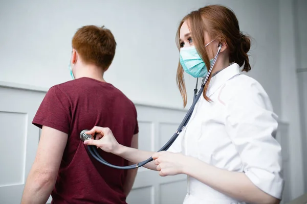 Paciente reclama ao médico bonito sobre tosse e mal-estar — Fotografia de Stock