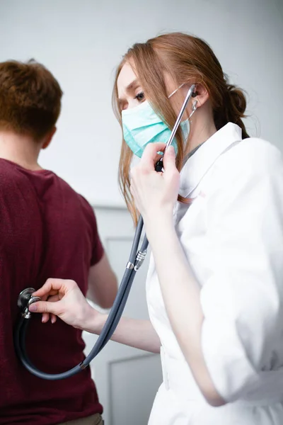 Paciente reclama ao médico bonito sobre tosse e mal-estar — Fotografia de Stock