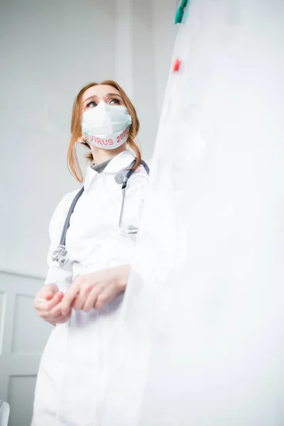 Beautiful red-haired doctor examines the data and statistics of patients with a new virus in 2020 — Stockfoto