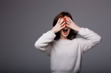 İtalyan kız elleriyle gözlerini kapatıyor ve stres ve virüsten korktuğu için bağırıyor.