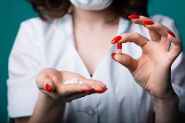 Yakın görüş - güzel manikürlü bir kız doktor hastalığı çeşitli virüslerle tedavi etmek ve önlemek için ilaç ve hap bulundurur.