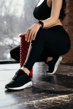 Siyah elbiseli koç masaj yastığının karşısına oturmuştu. Spor silindirli gündüz eğitimi