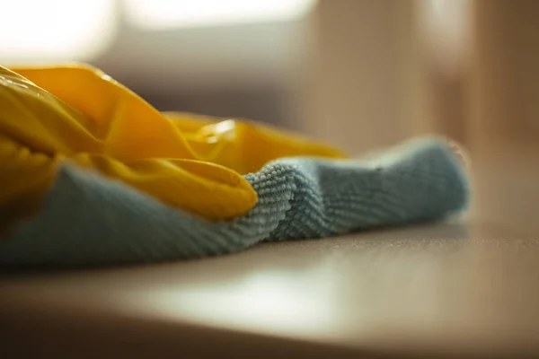 Toz almak için mavi bez ve temizlik için sarı eldiven. — Stok fotoğraf