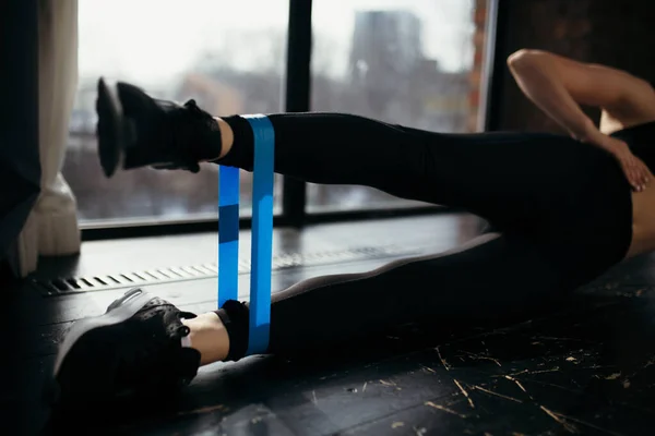 Wanita olahraga hitam membuat latihan dengan tinggal di rumah pada otot-otot kaki. Latihan untuk memperkuat tubuh.. — Stok Foto