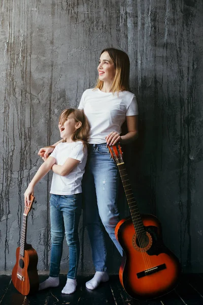 Vacker mor och dotter lär sig att spela gitarr under karantän och isolering — Stockfoto