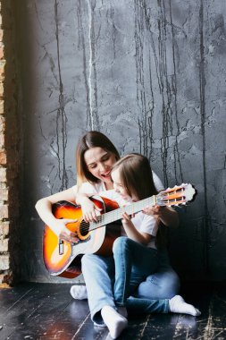 Güzel anne ve kız karantina ve izolasyon sırasında gitar çalmayı öğreniyorlar.