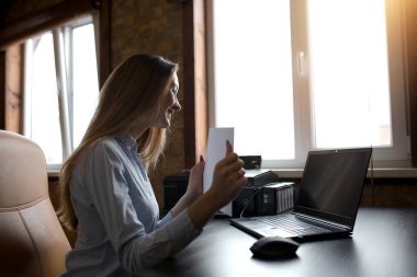 İspanyol kız akşam stüdyoda dizüstü bilgisayarın önünde oturuyor ve dosyasının bilgilerini arkadaşına gösteriyor..