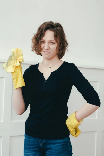 Παιχνιδιάρικο κορίτσι με κίτρινα γάντια και ένα κουρέλι καθάρισε το διαμέρισμα. Σκόνη και χώμα στο κίτρινο πανί. — Φωτογραφία Αρχείου