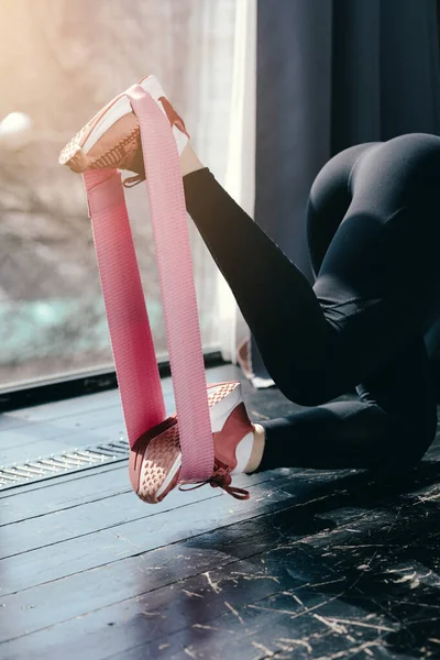 Primer plano. Patas largas en leggins negros con una correa de caucho rosa deportivo. Piernas tonificadas y culo de hermosa chica . — Foto de Stock