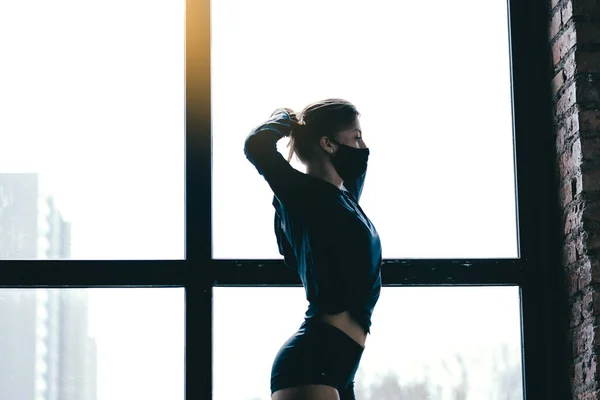 Une belle silhouette de fille de profil. Figure tendue d'un entraîneur de boxe. jambes maigres, cul costaud, et des vêtements noirs . — Photo