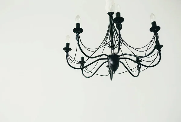 Starožitný dekorativní lustr v klasickém interiéru. Držáky svíček a žárovky v lustru. Bílé pozadí. — Stock fotografie