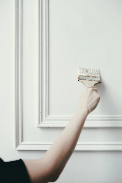 女性の手は白い塗料で装飾的な成形や壁のブラシをペイント。内装の修復と改装. — ストック写真