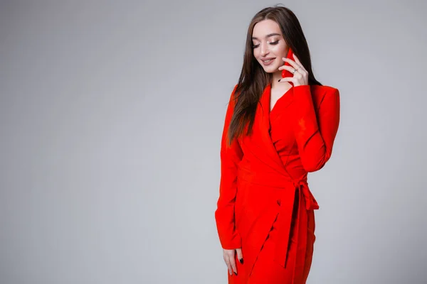 Μοντέρνο κορίτσι με κόκκινο φόρεμα που μιλάει στο τηλέφωνο. Φωτογραφία πορτρέτο μιας όμορφης επιχειρηματία. — Φωτογραφία Αρχείου